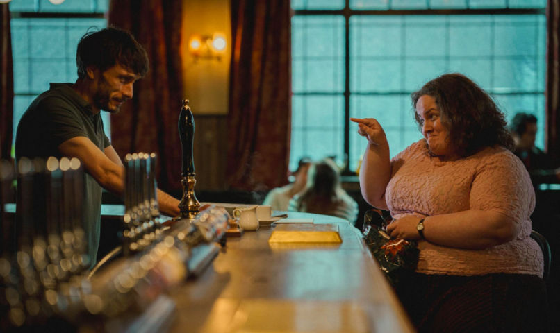a photo of donny dunn, played by richard gadd, interacting with martha scott, a character from baby reindeer inspired by fiona harvey and played by jessica gunning