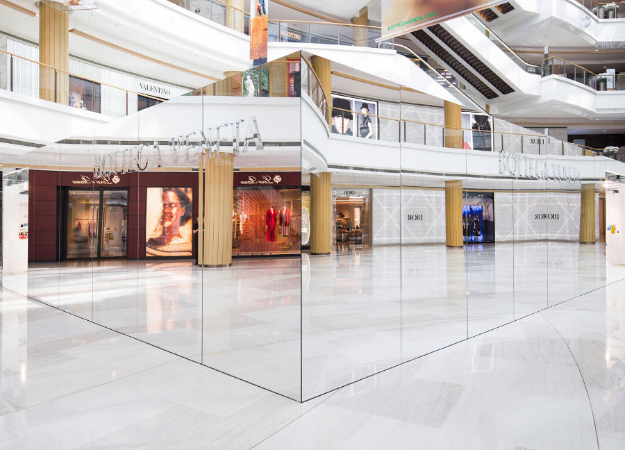 The Invisible Store is camouflaged by the reflections of logoed windows and signs inside the luxury mall’s atrium